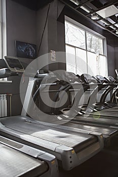 Empty treadmills in a row at sports studio