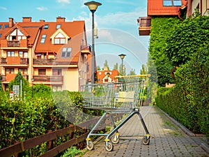 empty trolley shopping cart outside near apartment house entrance