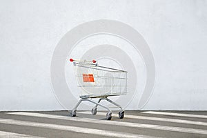 Empty Trolley at the Supermarket. Grocery Cart on the White Wall Store. Shopping Cart Trolley Stands near Mall with Copy