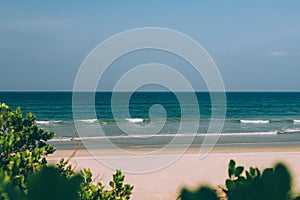 Empty tropical beach background, waves on the sea, blue sky