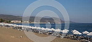 Empty tropical sandy coast with white beach umbrellas. Summer vacations at sea