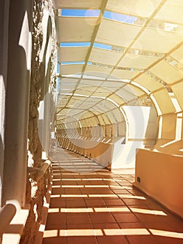 Empty tunnel with footpath lit by sunset. Light-lit architectural corridor.