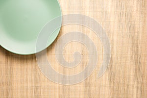 empty turquoise plate on a bamboo napkin, top view