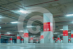 Empty underground car parking lot. Underground car parking garage at shopping mall or international airport. Indoor parking area.