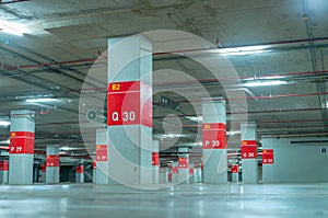 Empty underground car parking lot. Underground car parking garage at shopping mall or international airport. Indoor parking area.