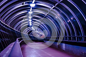 Empty underground passage with neon glowing lights. Perspective of crossrail tunnel
