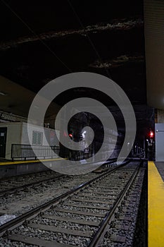 Empty underground train tunnel. Dark subway station.