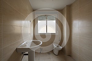 An empty unfinished bathroom with dirty tiles and uninstalled sanitary ware photo