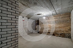 Empty unfurnished basement room with minimal preparatory repairs. interior with white brick walls