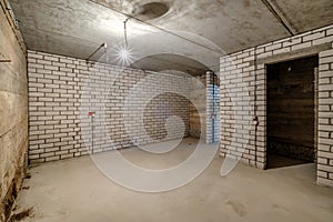 Empty unfurnished basement room with minimal preparatory repairs. interior with white brick walls