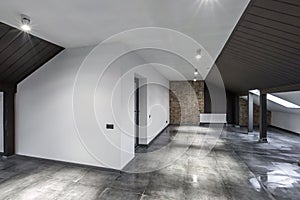 Empty unfurnished loft mansard room interior with wooden columns and wet concrete floor on roof level in black and whote style