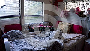 Empty unmade girly young female girl bed room with many toys and staff animals in color pink with many pillows