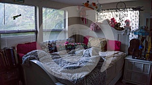 Empty unmade girly young female girl bed room with many toys and staff animals in color pink with many pillows
