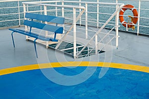 Empty upper deck with blue wooden bench and helicopter pickup point on Greek ferry