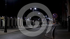 Empty urban street, night scenery in the city with street lamps on black sky background. Stock footage. Late evening