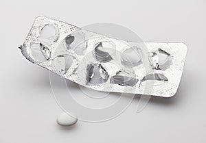 Empty, used, opened blister with last one white pill on white background - healthcare and medicament concept. Pharmaceutical