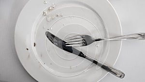 Empty used plate with a knife and fork placed on it