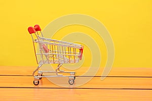 Empty used shopping trolley photo on Wooden board backgorund