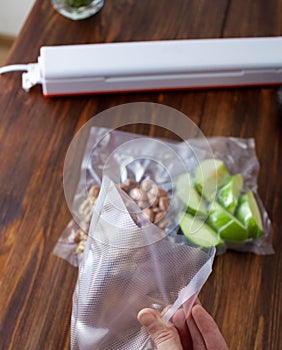 An empty vacuum bag in a woman`s hand against the background of vacuum bags