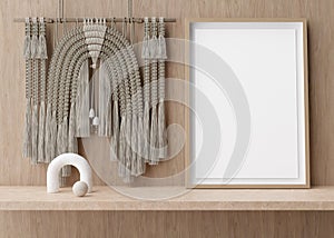 Empty vertical picture frame standing on shelve in modern room. Mock up interior in contemporary, boho style. Free, copy