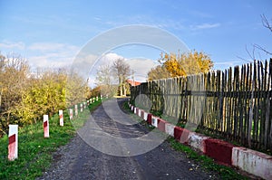 Empty village road among traditional wooden fence