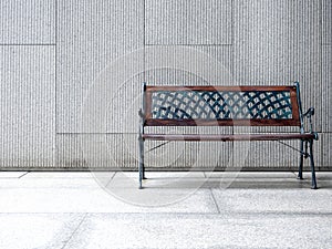 Empty vintage bench chair seat with wood and black wrought iron materials, decorated on concrete tiles floors.