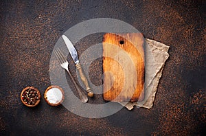 Empty vintage cutting board with spices and cutlery