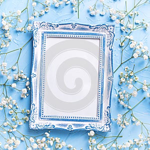 Empty vintage frame and fresh white gypsofila flowers photo