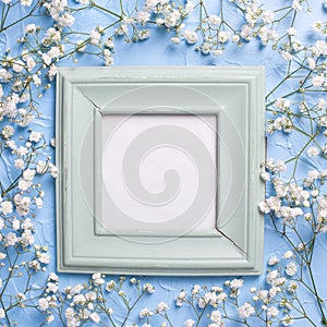 Empty vintage green frame and fresh white gypsofila flowers photo