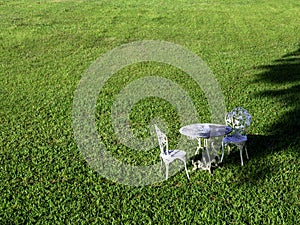 Empty vintage wrought iron garden round table and two chairs.