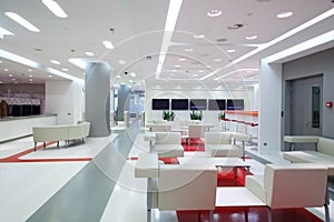 Empty waiting area with white chairs and plasma