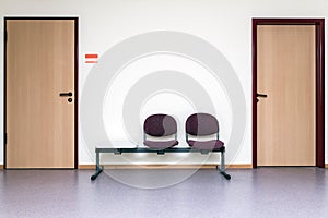 Empty waiting room in a hospital or clinic, two chairs and two doors