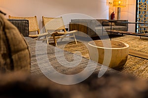 Empty waiting room with sofa and wooden chairs illuminated with warm light in a hotel. Tourist concept