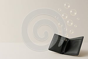 An empty wallet with floating glowing bubbles. Space for text.