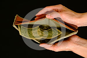 Empty wallet with one dollar on black background