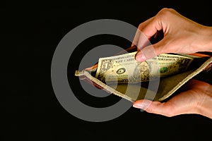 Empty wallet with one dollar on black background