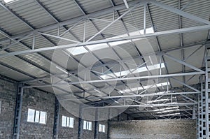 Empty warehouse. Brick walls, windows in the walls and ceiling. Modern interior of a warehouse, factory