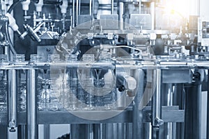 The empty water bottles  on the conveyor belt for filling process in the filling machine