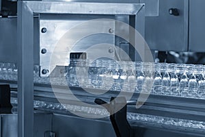 The empty water bottles  on the conveyor belt for filling process in the filling machine