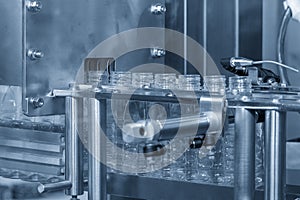 The empty water bottles  on the conveyor belt for filling process in the filling machine