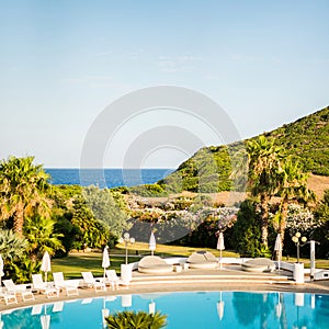 Empty Water Pool with Sunbeds with Umbrellas. Mediterranean Landscape