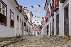 A colonial architecture street adorned with flags for the Divine Holy Spirit Festivity in Paraty, Brazil.