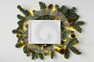 Empty white border with garland of fir branches and lights on a white background