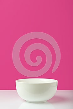 Empty white bowl with copy space on pink
