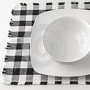 Empty white bowl and plate on napkin