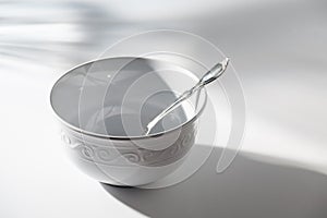 Empty White Bowl with Spoon on a White Background