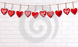 Empty white brick wall with red heart shape garland. Valentines day concept