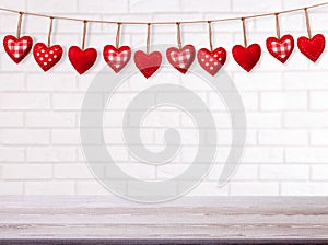 Empty white brick wall with red heart shape garland. Valentines day concept