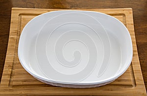 Empty White Casserole Dish on Wood Cutting Board