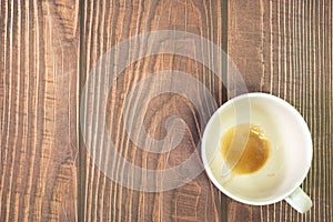 Empty white ceramic cup coffee after drink on wooden table background